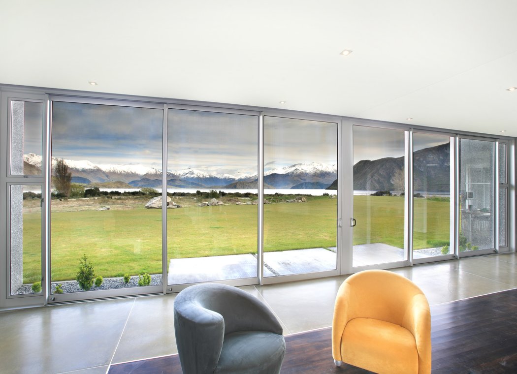 Aluminium sliding doors opening onto lake and mountain views